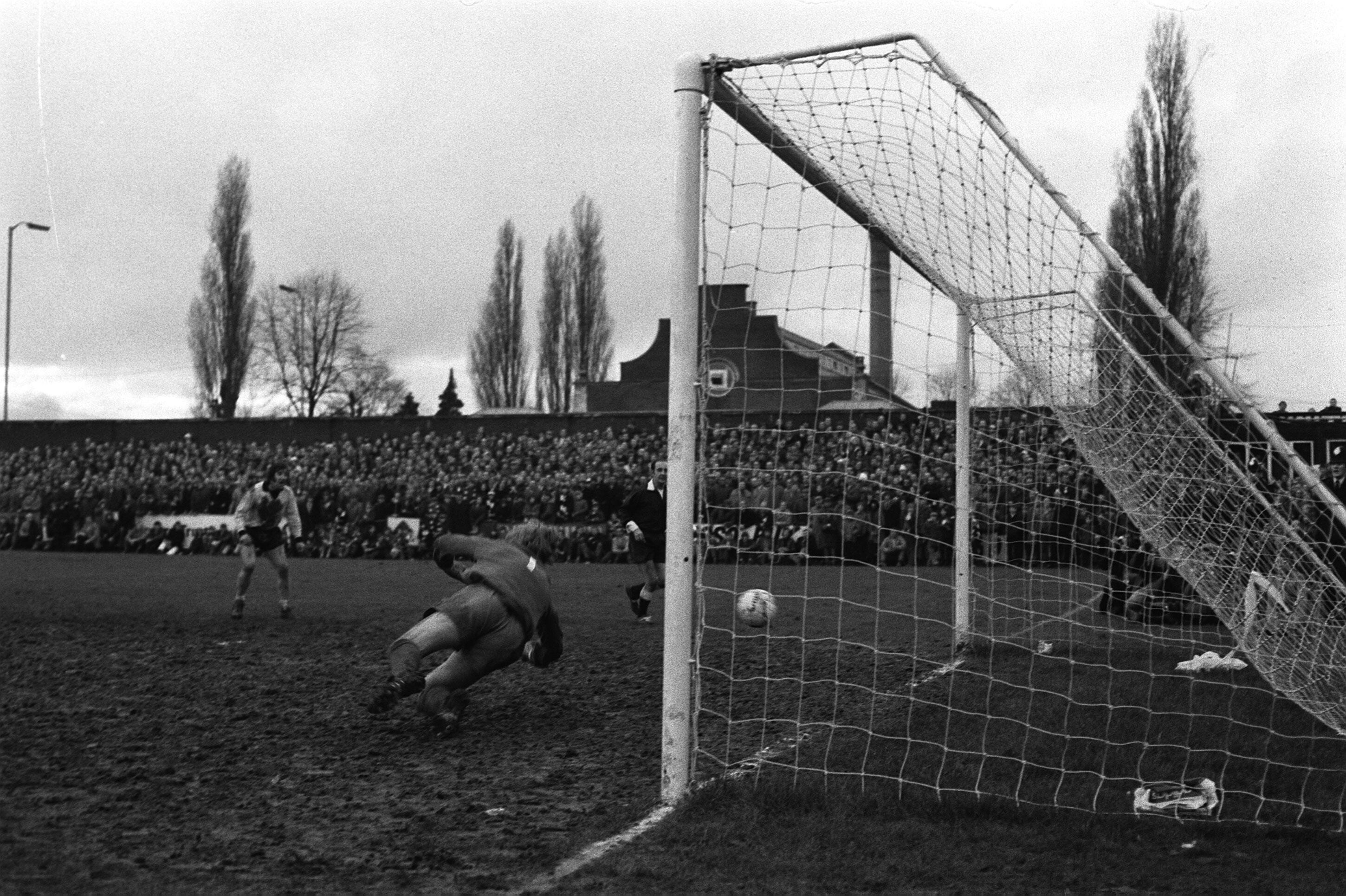 WILLIAM MCFAUL THE NEWCASTLE UNITED GOALKEEPER FAILS TO STOP A SHOT FROM HEROIC HEREFORD'S SUBSTITUTE RICKEY GEORGE WHICH GAVE AN EXTRA TIME GOAL TO THE NON LEAGUE TEAM WHICH BEAT 1ST DIVISION NEWCASTLE 2-1 AT EDGAR STREET GROUND IN THE F.A. CUP 3RD ROUND REPLAY