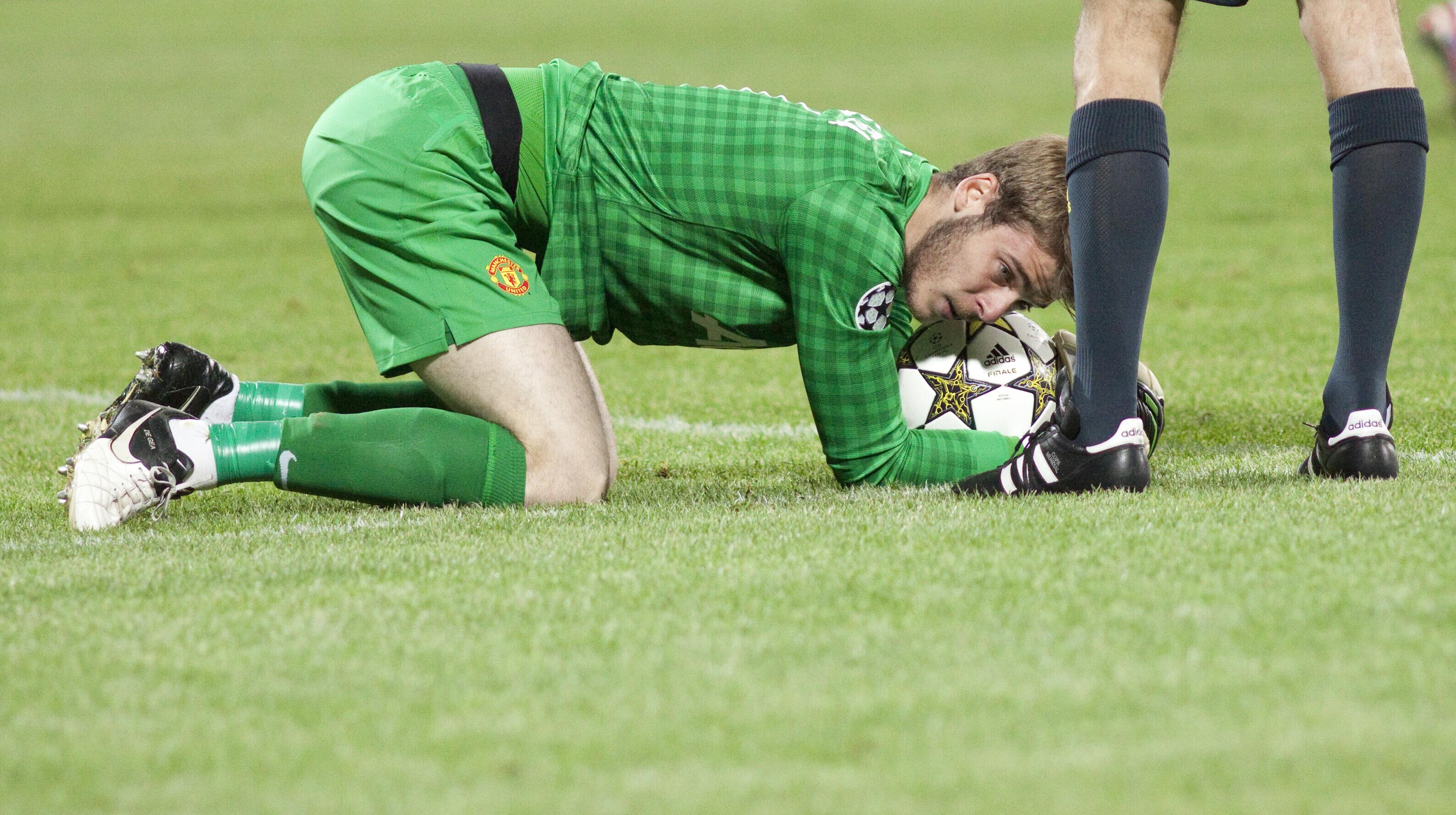 picture of manchester United goalkeeper Gavid De Gea on is hands and knees holding the ball