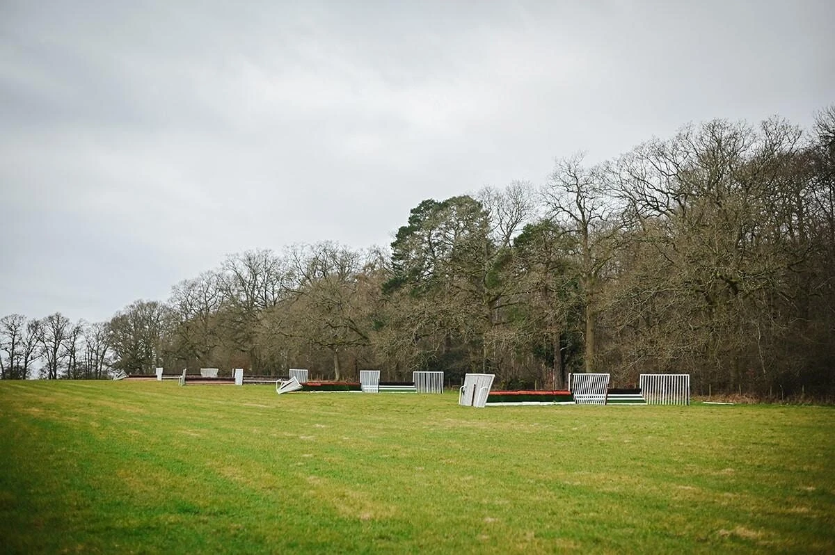 Line of grass schooling jumps in the field at Harry Derham Racing