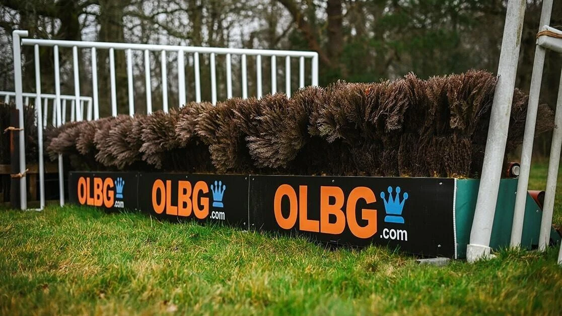 A schooling fence at Harry Derham Racing with OLBG signage