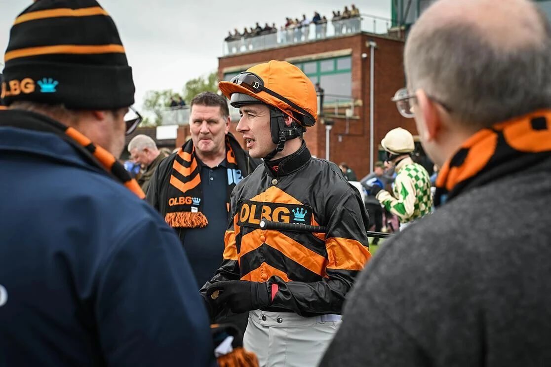 Members of the OLBG Racing Club talking with jockey Paul OBrien in the parade ring ahead of one of the OLBG Racing Club horses running